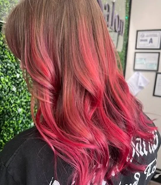 Vivid red and pink color melt on long wavy hair