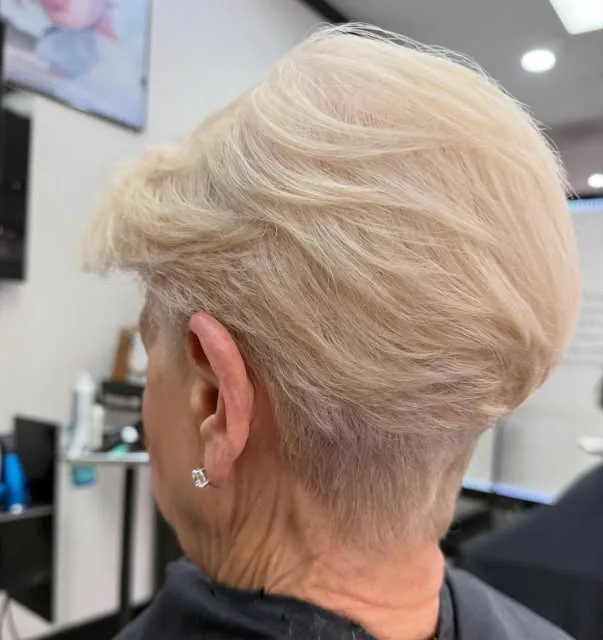 Short platinum blonde pixie haircut by Desiree