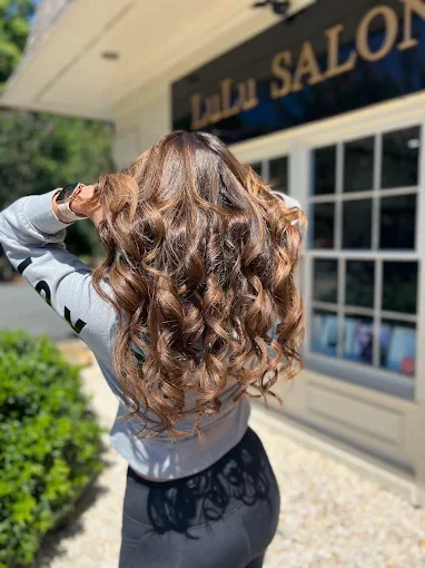 Client with finished dimensional curls outside LuLu Salon in Waxhaw