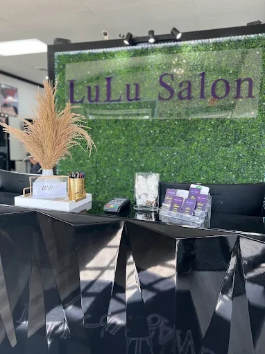 LuLu Salon reception desk with the signature green living wall and purple sign